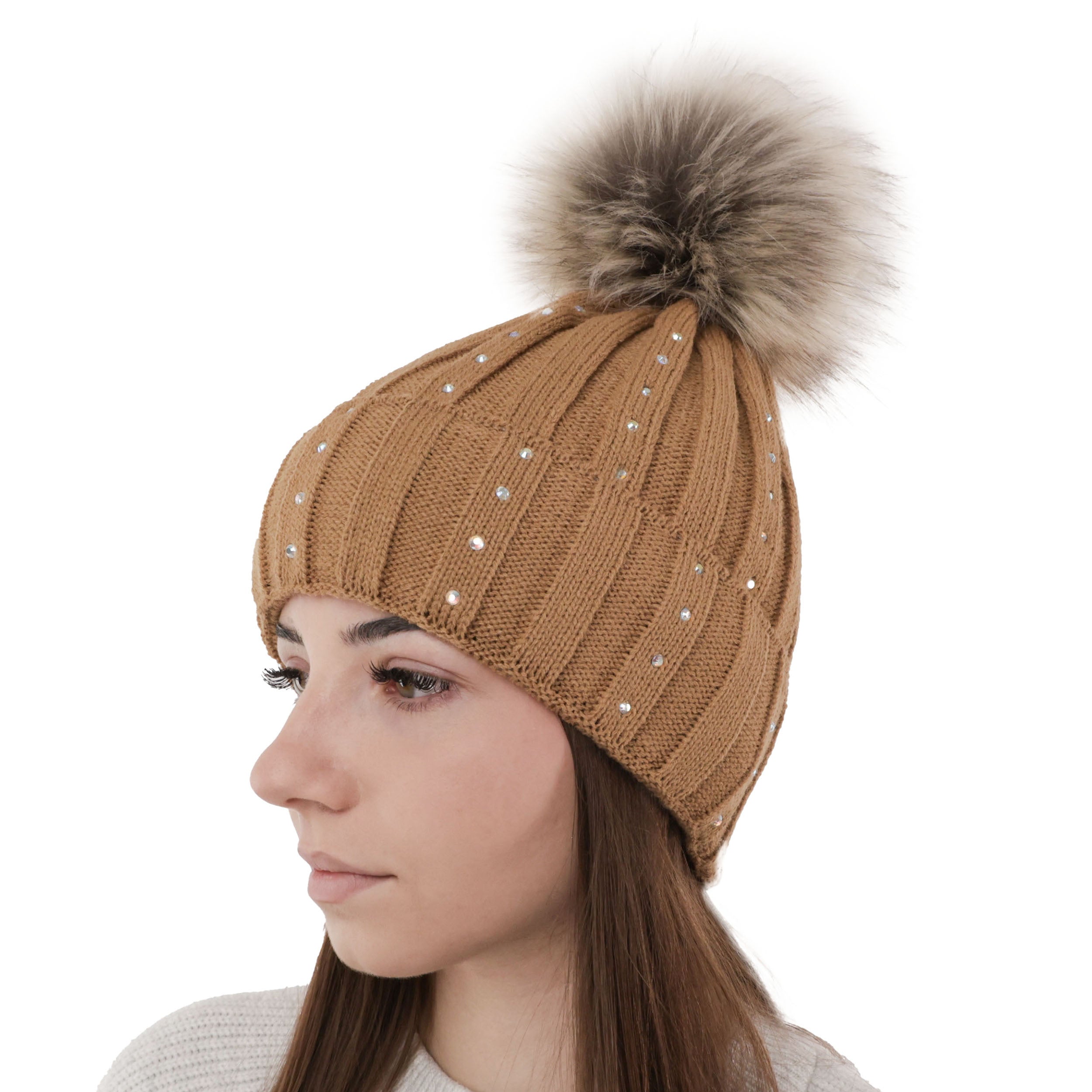 Femeie purtand caciula de iarna camel Mira, tricotata, cu pompon si aspect elegant.
