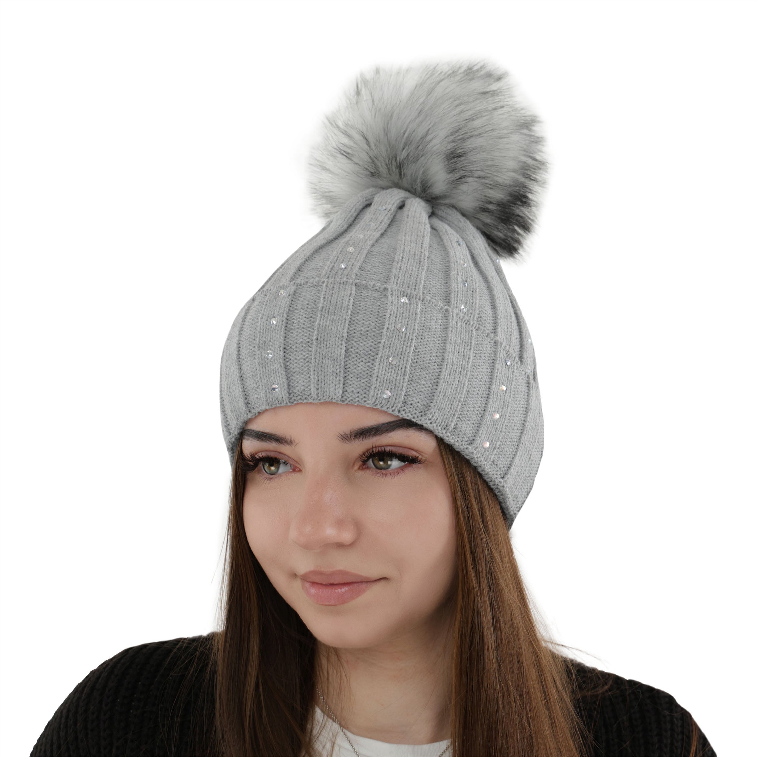 Femeie purtand caciula de iarna gri deschis Mira, tricotata, cu pompon si aplicatii discrete.
