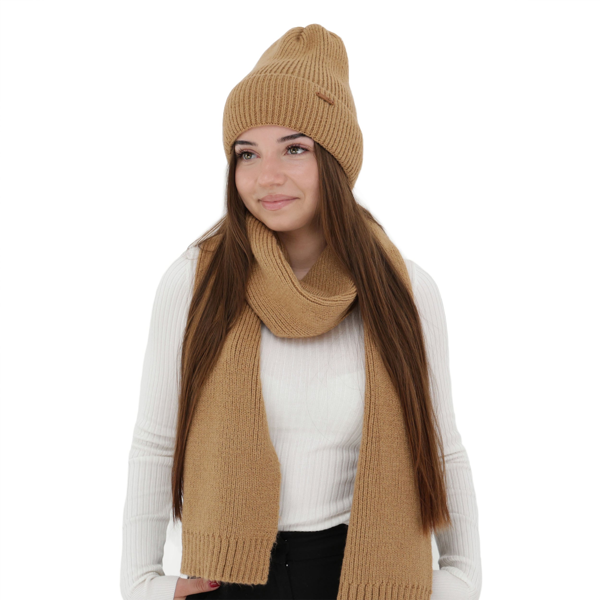Femeie purtând set de iarnă camel din lână merinos — căciulă și fular tricotate, moi și călduroase.