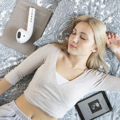 Boxă Funsker pe pat, fata se relaxează, ascultând muzică via Bluetooth de pe tabletă.