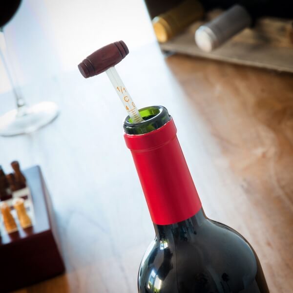 Termometrul setului in timp ce este introdus intr-o sticla de vin rosu.