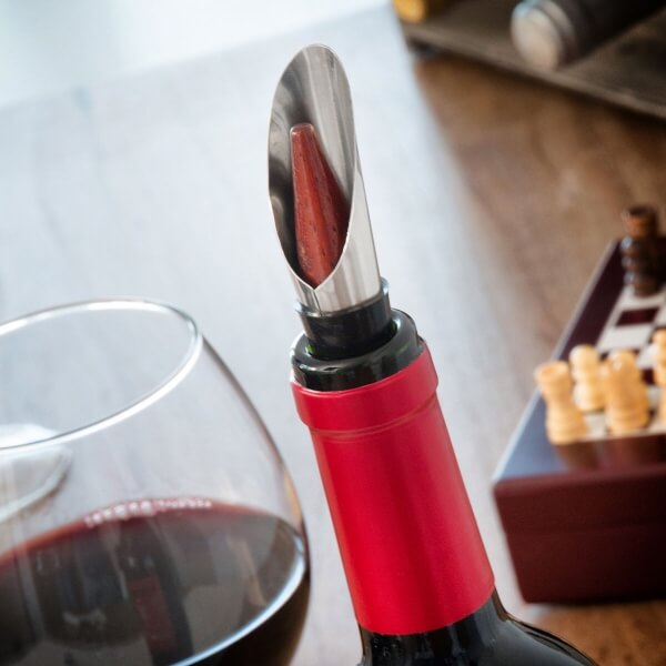 Instrumentul de turnare in timp ce este introdus intr-o sticla de vin rosu.
