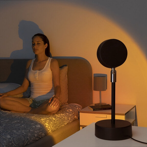 Sunset Lover - Proiector Apus de soare lumineaza o fata in timp ce se relaxeaza si face yoga in pat.